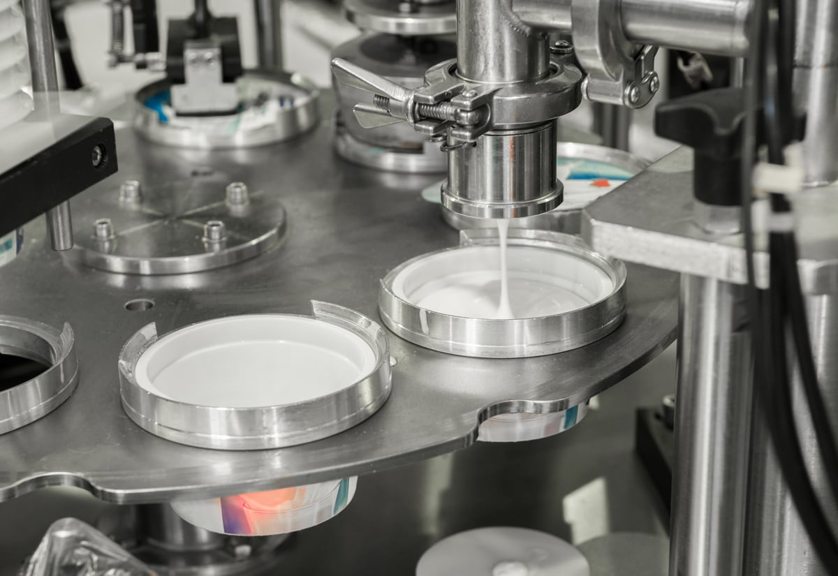 dispensing yogurt into cups on automated production line